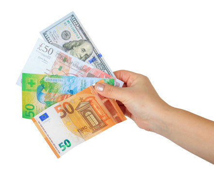 women's hand holding a money fan with four currencies