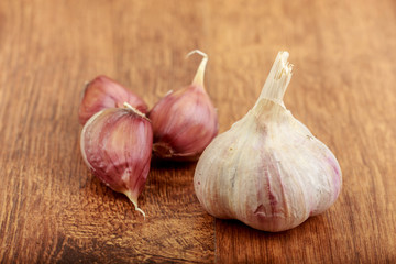 whole garlic and garlic cloves on wooden table