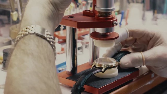 watchmaker replaces the glass in a wristwatch, close-up