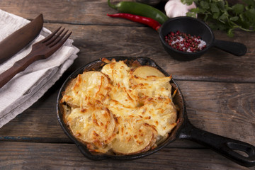 potato casserole with cheese in a frying pan serving vegetarian dish homemade