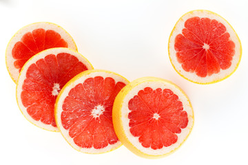 A fresh ripe juicy and appetizing grapefruit and its parts close-up, isolated on a white background..