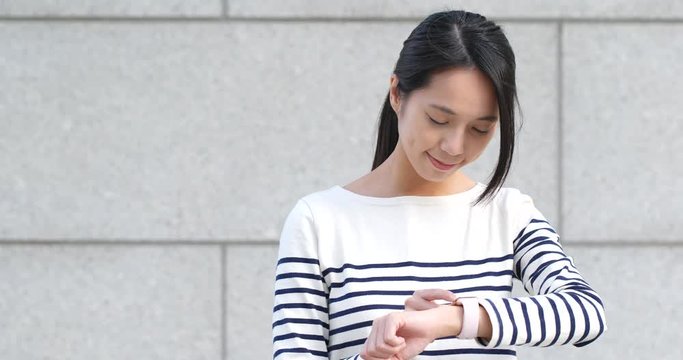 Young woman using smart watch for checking time schedule