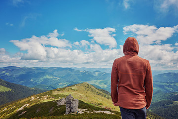 Hiker standing on a cliffs edge. The top of the mountain.