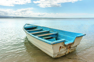 Fototapeta na wymiar empty old wooden boat on shallow water