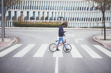 Male BMX rider on street with phone