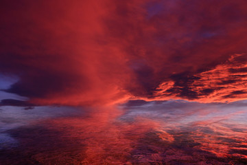 Czerwone chmury po zachodzie słońca odbite w morzu - obrazy, fototapety, plakaty