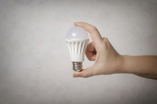 Male hand holding a white led light bulb