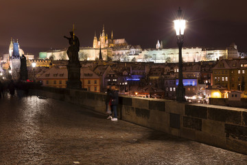 Night colorful snowy Christmas Prague Lesser Town with gothic Castle from Charles Bridge, Czech...