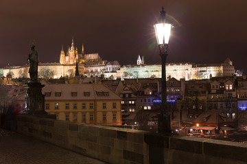 Fototapeta premium Night colorful snowy Christmas Prague Lesser Town with gothic Castle from Charles Bridge, Czech republic