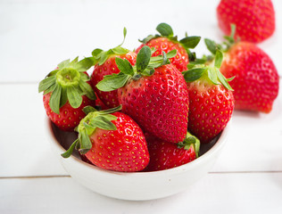 The red strawberry in big bowl ,put on timber board,blurry light around.