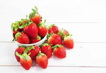 Closeup group of red strawberry at the left side on timber board,blurry light around.fresh fruit,high vitamin and good for health.