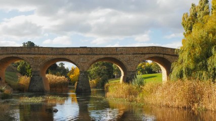 a sunny autumn view of the historic old stone bridge in richmond, tasmania, the oldest bridge still being used in australia