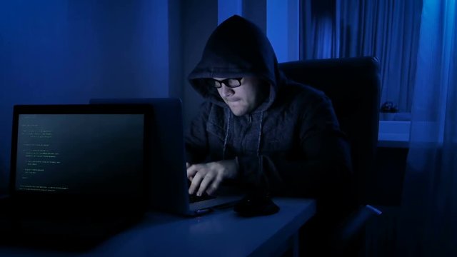 Funny 4k footage of male pretends to be hacker. Man working on laptop at night