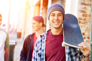 Teenager boy walking at the street with his skateboard © Sergey Nivens