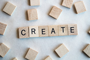 Wooden letters spell the word create, with blank tiles around the edges