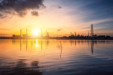 Fototapeta na wymiar Oil and gas industry - refinery at Sunrise - factory - petrochemical plant with reflection over the river