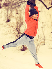 Fototapeta na wymiar Woman wearing sportswear exercising outside during winter