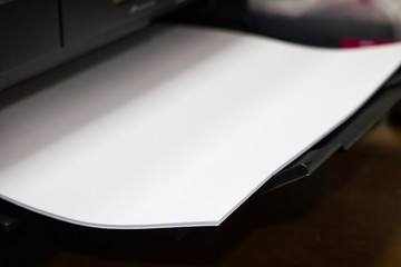 close-up white paper sheets on the printer in office.
