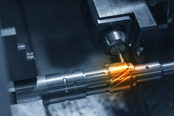 The CNC lathe machine cutting the steel shaft. The slot cutting process on the metal shaft with the turn-mill machine.