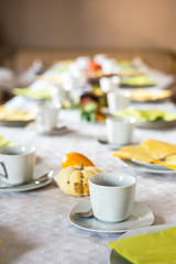 Beautiful festive dinner table colorful yellow fall helloween pumpkin decoration coffee mugs saucers plates and spoons