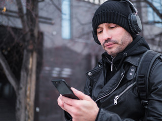 Man looking for a place using GPS map in smartphone. He lost in unknown city. he is dressed in a...