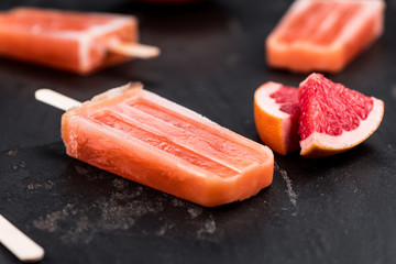Slate slab with fresh Grapefruit Popsicles (selective focus)