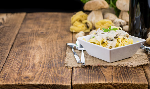 Porcini pasta on wooden background; selective focus