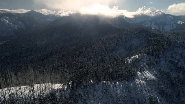 Aerial Time-Lapse Panning Mountain Cloud Movement in Winter Snow