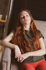 young beautiful redhead hipster woman with no make up relaxing at home. Youth and natural beauty concept.