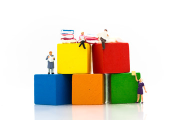 Miniature people: sitting on book and read book for increase knowhow using as learning never ends, education concept.