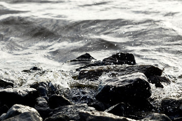 Coastal rocks on wave background