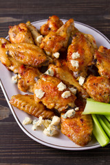 Chicken wings buffalo with blue cheese and celery sticks, vertical