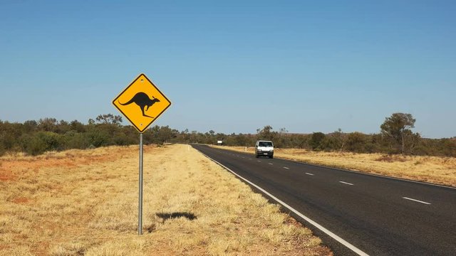 a van drives past a kangaroo road sign in outback australia