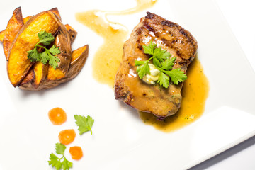 meat with grilled vegetables on a plate on white background