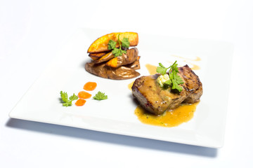 meat with grilled vegetables on a plate on white background