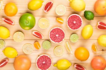 different tasty citrus fruits on a light wooden table