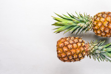 Pineapple on a wooden background. Top view. Free space for text.