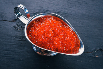 Red salmon caviar. On a wooden background. Top view. Free space for text.