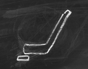 Ice hockey stick and puck on chalkboard, blackboard background and texture