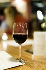 Wine glass filled with red wine on table in pub