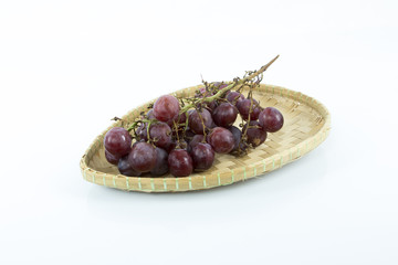 Red grape on the bamboo mat isolated on white background