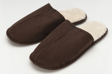 Pair of brown slippers on white background