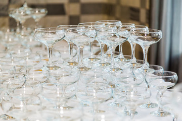 Many empty champagne glasses on the table in the restaurant.