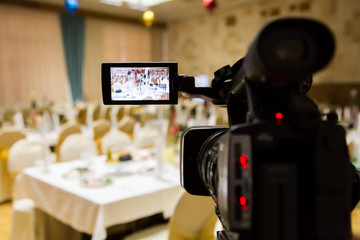Fototapeta na wymiar Filming of the event. Videography. Served tables in the Banquet hall.