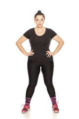 Fototapeta premium Chubby woman posing in fitness clothing on white background