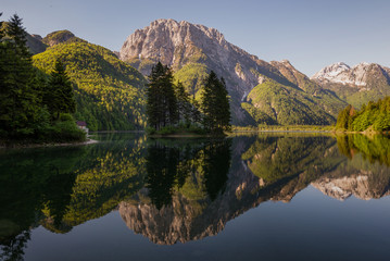 Reflections in Lago del Predil in the morning in Tarvisio municipality in Italy