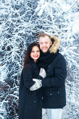 Happy Young Couple in Winter Park hugging .Family Outdoors.