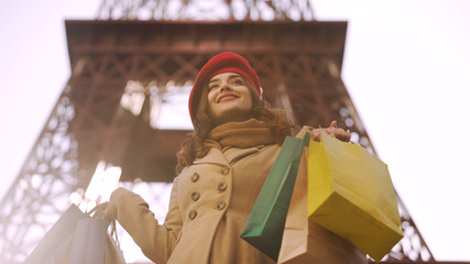 Beautiful lady having successful shopping in Paris, shopaholic with many bags