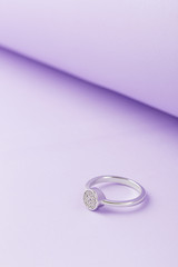 Wedding or engagement silver ring on violet background