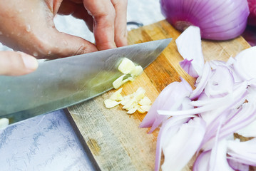 Female Hands Cutting Onions On Chopping Board